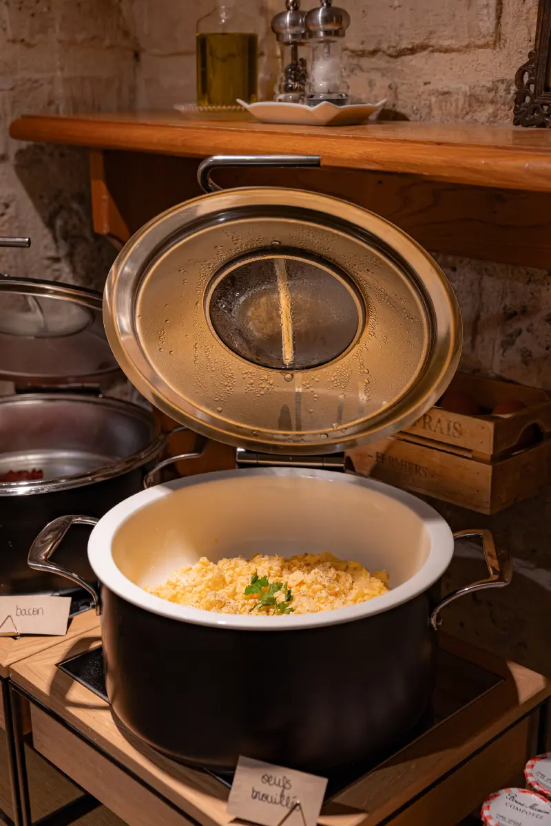 Cocotte de buffet chaud ouverte avec oeufs brouilles garnis de persil, etiquette oeufs brouilles